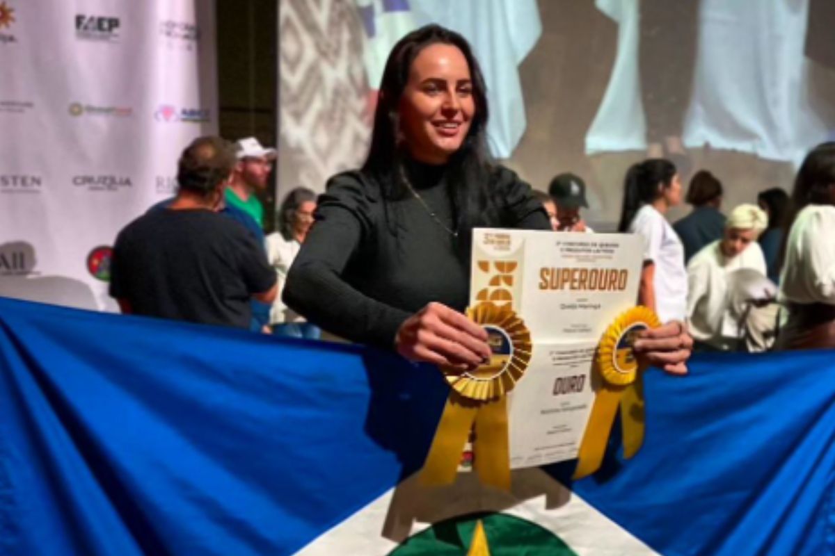 Foto mostra Raquel Cattani segurando certificado de premiação em campeonato de queijos.